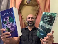 a man holding two books in front of him